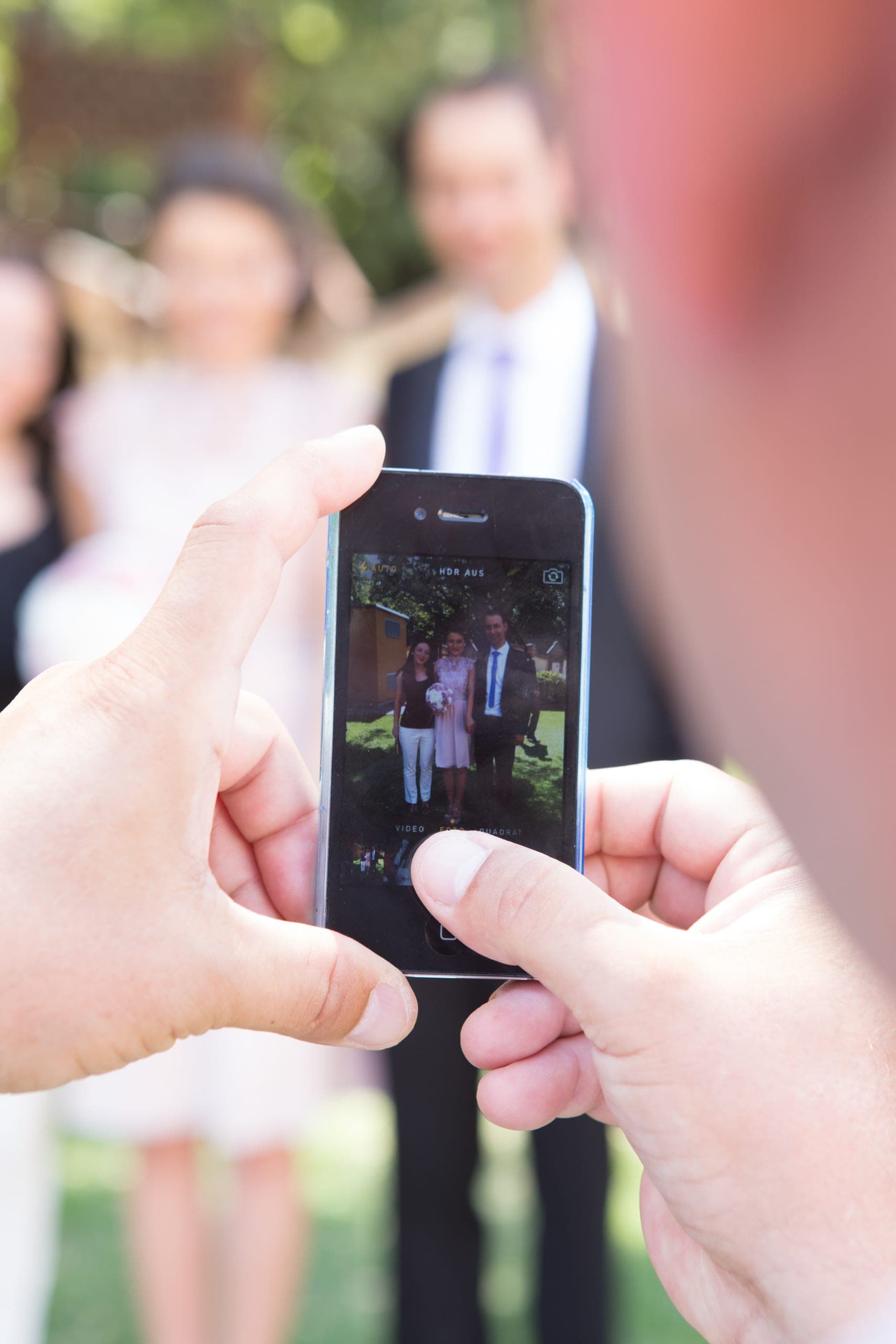Un invitat arătând poza de grup pe telefon